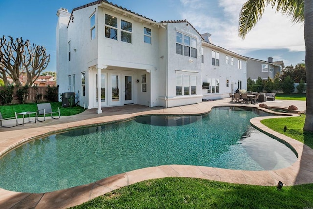 back of property with french doors, stucco siding, central AC unit, a patio area, and fence