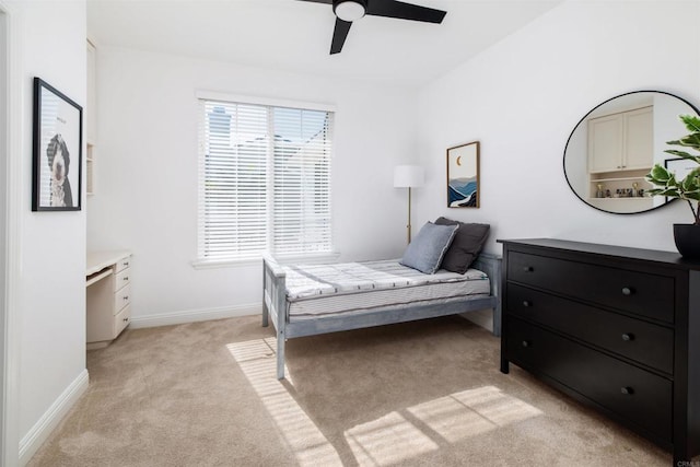 bedroom with baseboards, a ceiling fan, and light colored carpet