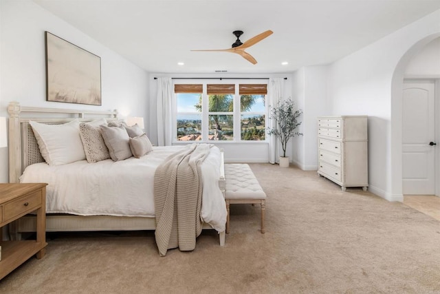 bedroom featuring arched walkways, recessed lighting, light colored carpet, a ceiling fan, and baseboards