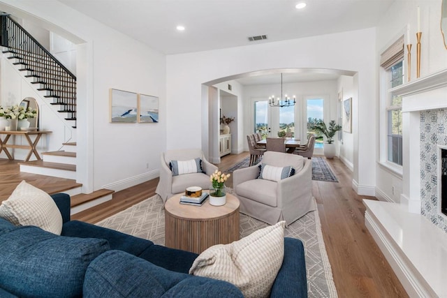 living room with recessed lighting, visible vents, stairway, wood finished floors, and baseboards