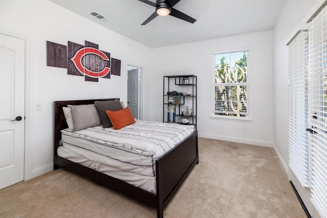 bedroom with baseboards, visible vents, and light colored carpet