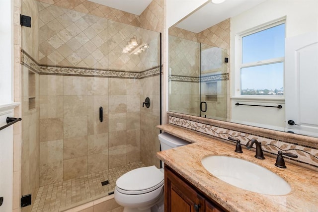 full bath featuring toilet, a stall shower, and vanity