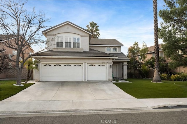 traditional home with a garage, driveway, a tiled roof, a front yard, and stucco siding