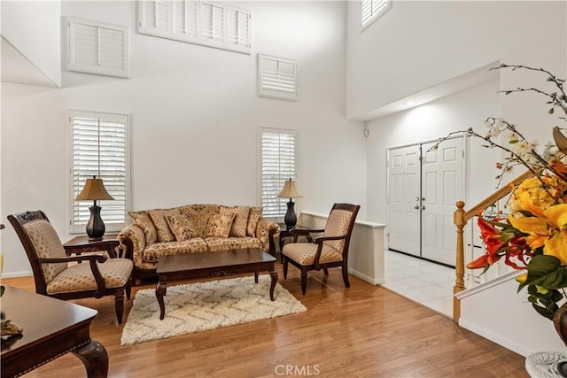 23718 Hathaway Dr, Valencia, CA 91354 - living room featuring a towering ceiling, light wood-style flooring, and baseboards