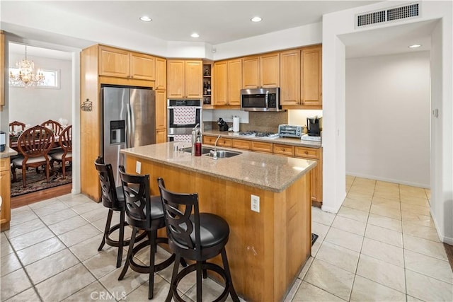 23718 Hathaway Dr, Valencia, CA 91354 - kitchen with stainless steel appliances, a chandelier, light tile patterned floors, light stone counters, and recessed lighting