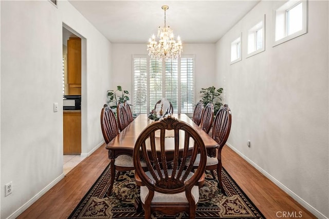 23718 Hathaway Dr, Valencia, CA 91354 - dining area with a chandelier, wood finished floors, and baseboards