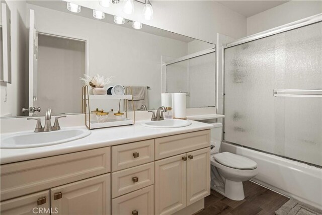 23718 Hathaway Dr, Valencia, CA 91354 - full bathroom featuring double vanity, wood finished floors, toilet, and shower / bath combination with glass door