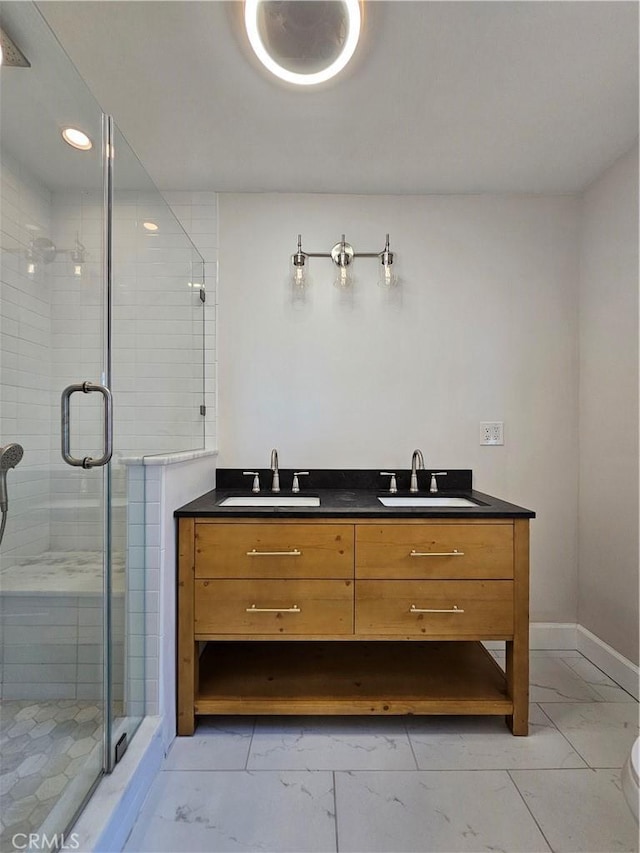 full bath with marble finish floor, a stall shower, and a sink