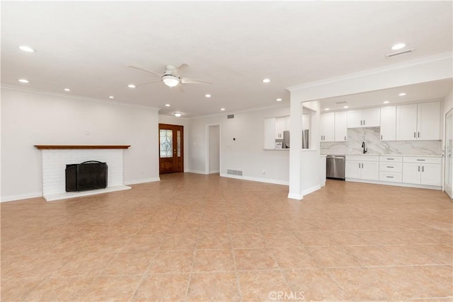 unfurnished living room featuring visible vents, a fireplace, baseboards, and a sink