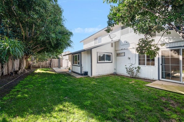 back of property featuring fence and a yard