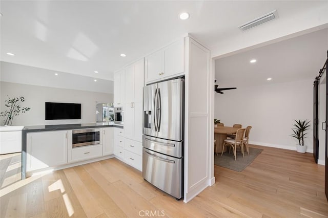 kitchen featuring light wood finished floors, appliances with stainless steel finishes, visible vents, and white cabinetry