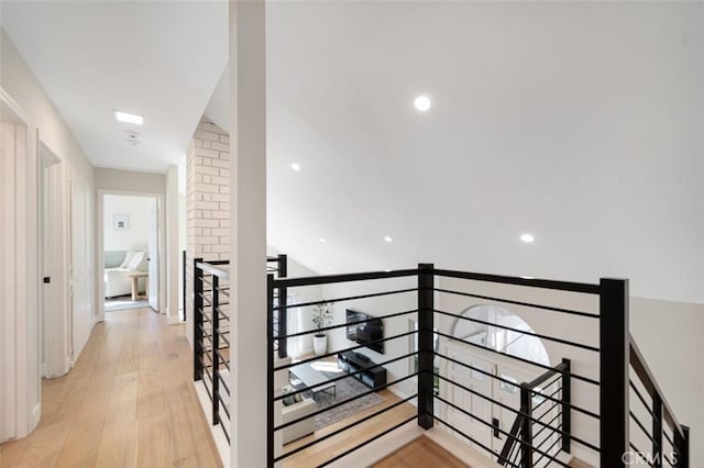 corridor featuring light wood-style floors and an upstairs landing