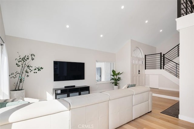 living area featuring light wood-style floors, stairs, vaulted ceiling, and recessed lighting