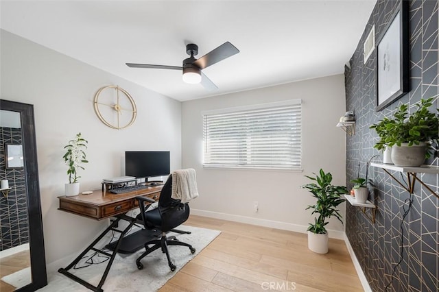 office space featuring light wood finished floors, a ceiling fan, and baseboards