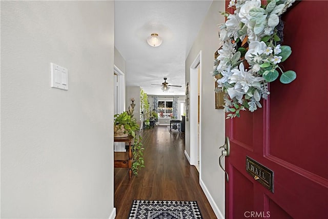 hallway with dark wood-style flooring and baseboards