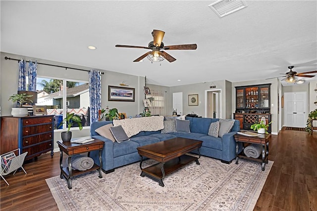 living room featuring baseboards, wood finished floors, visible vents, and a ceiling fan