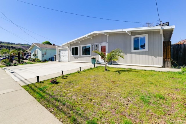 ranch-style home with a garage, driveway, a front lawn, and fence