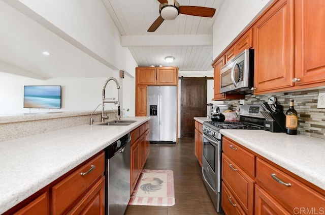 kitchen featuring stainless steel appliances, light countertops, a sink, and a barn door