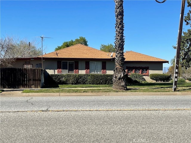 view of front of property with fence and stucco siding