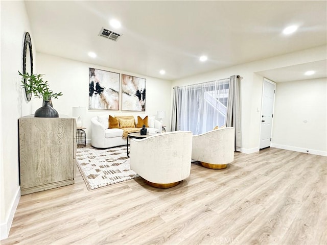 living area with recessed lighting, visible vents, and light wood-style floors