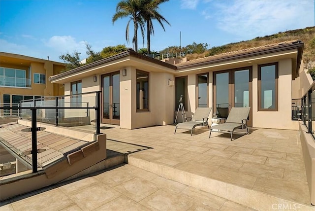 rear view of property with a patio and stucco siding