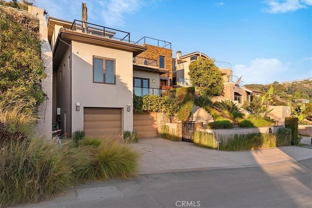 contemporary house featuring driveway, an attached garage, and stucco siding