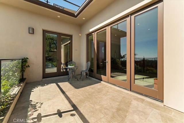 property entrance with french doors, a patio area, and stucco siding