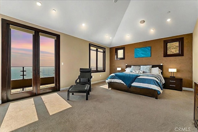 bedroom featuring access to exterior, french doors, light colored carpet, a water view, and vaulted ceiling