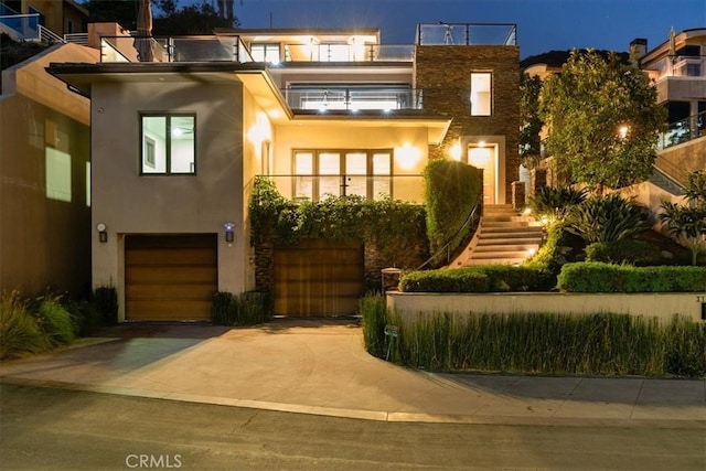 contemporary house featuring driveway, an attached garage, and stucco siding