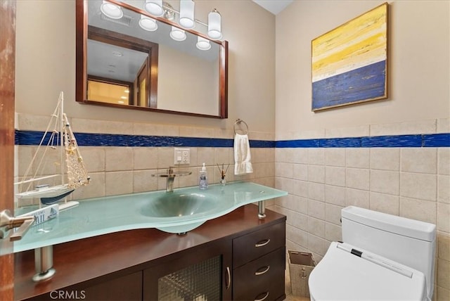 bathroom featuring tile walls, vanity, and toilet