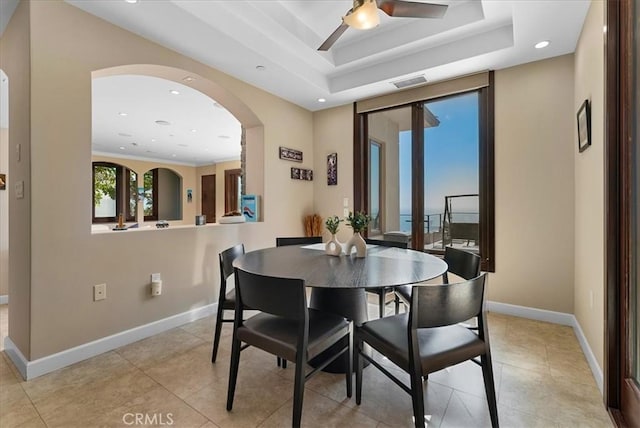 dining space with arched walkways, recessed lighting, visible vents, baseboards, and a raised ceiling