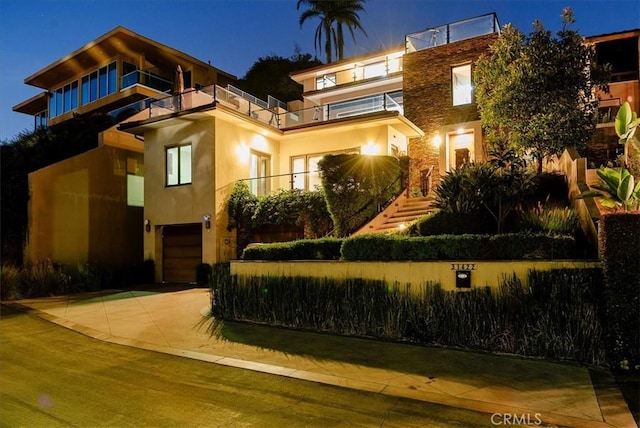 view of front of house featuring an attached garage, concrete driveway, and stucco siding