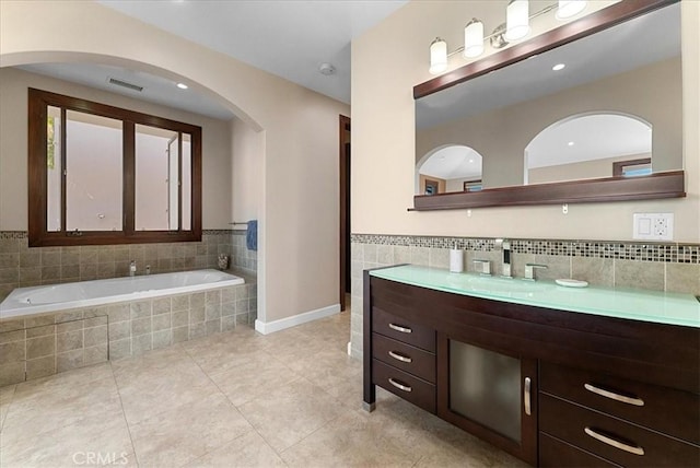 bathroom with visible vents, tile patterned flooring, a garden tub, and vanity