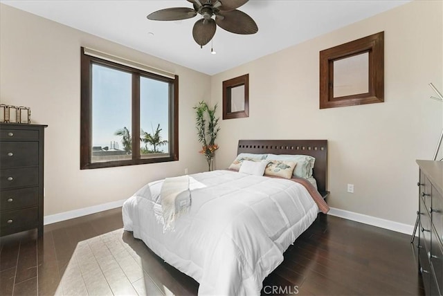 bedroom featuring ceiling fan, dark wood finished floors, and baseboards