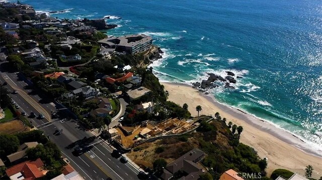 bird's eye view featuring a water view and a beach view