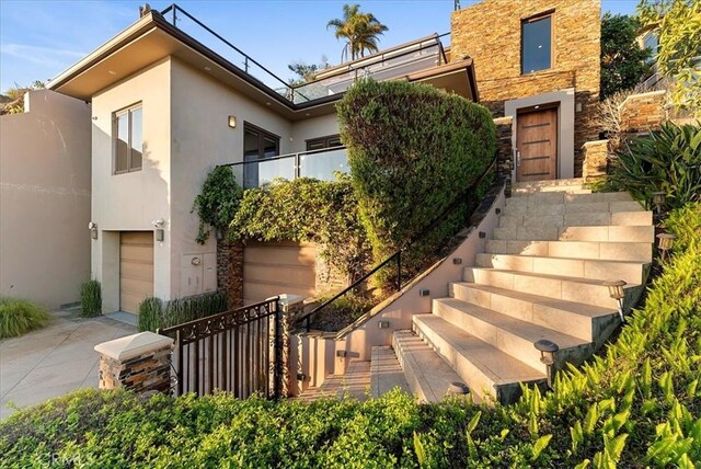 31422 Ceanothus Dr, Laguna Beach, CA 92651 - view of front of home with stairway, stucco siding, stone siding, and an attached garage