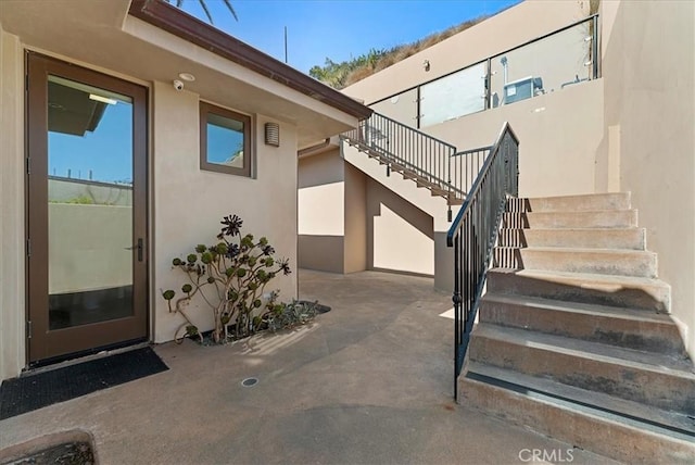 entrance to property with a patio area and stucco siding