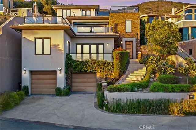 31422 Ceanothus Dr, Laguna Beach, CA 92651 - view of front of house with a balcony, stairs, concrete driveway, and stucco siding