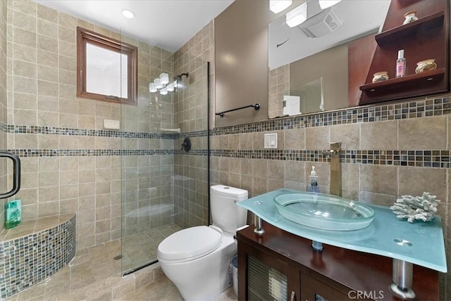 full bath featuring a stall shower, visible vents, toilet, vanity, and tile walls