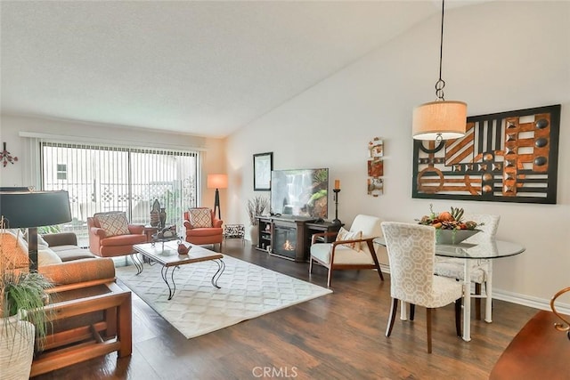 living room featuring high vaulted ceiling, baseboards, and wood finished floors