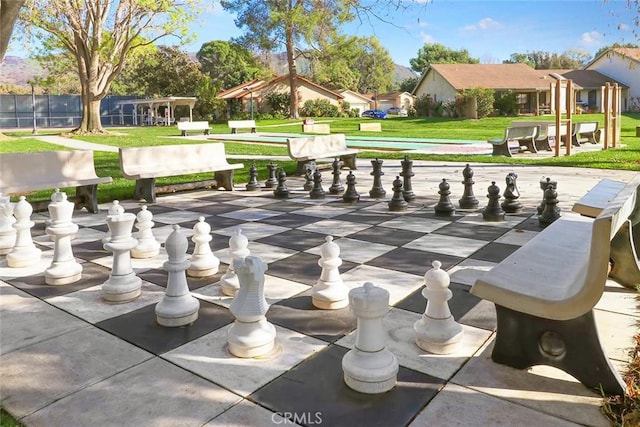 view of property's community featuring a yard and shuffleboard