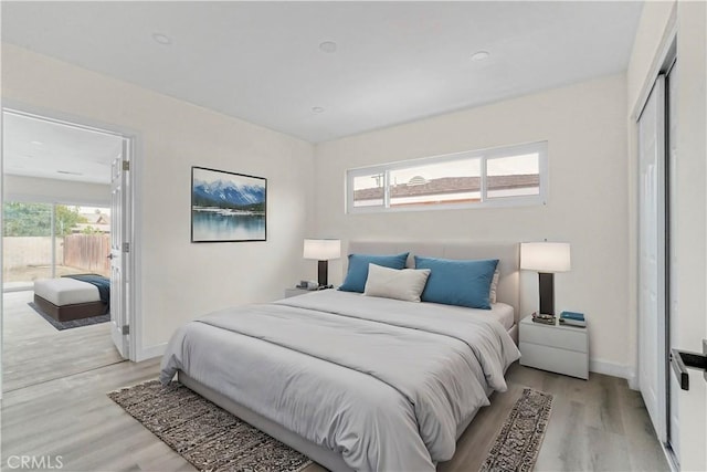 bedroom featuring light wood-style floors, a closet, and baseboards