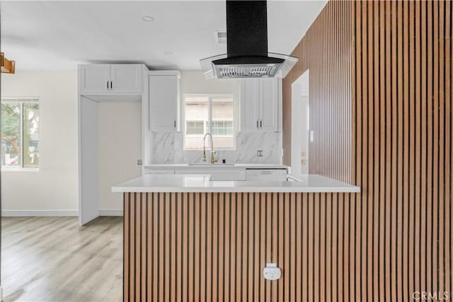 kitchen featuring extractor fan, white cabinetry, light countertops, and a sink