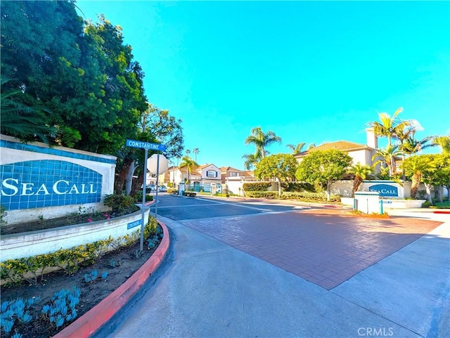 view of road with curbs, a gated entry, and a residential view