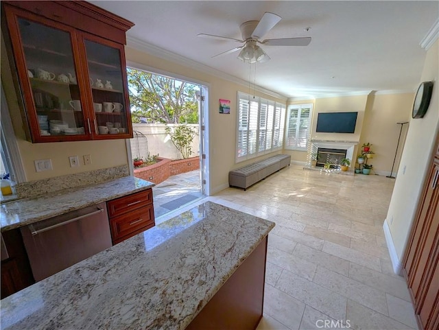 kitchen featuring light stone counters, stainless steel dishwasher, glass insert cabinets, a glass covered fireplace, and ornamental molding