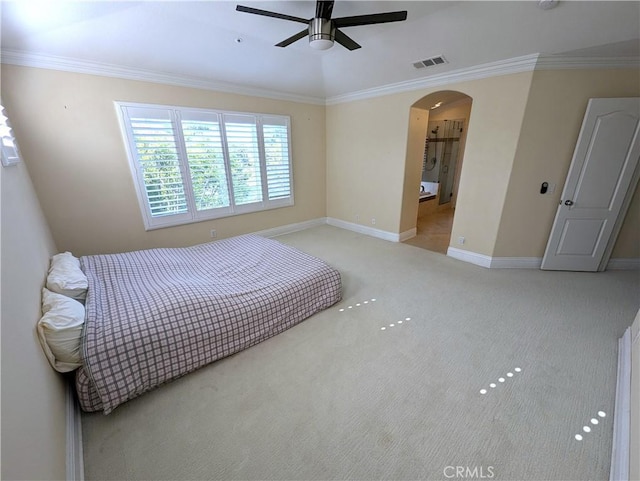 bedroom featuring arched walkways, carpet, visible vents, ornamental molding, and baseboards