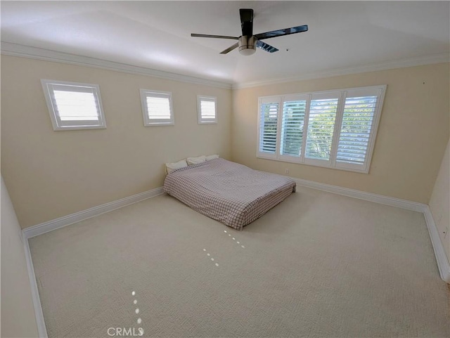 unfurnished bedroom featuring ornamental molding, carpet, ceiling fan, and baseboards