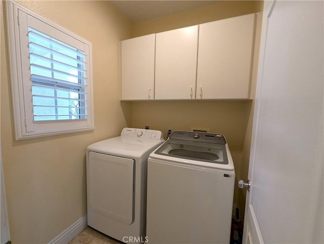 laundry room featuring washing machine and clothes dryer, cabinet space, and baseboards