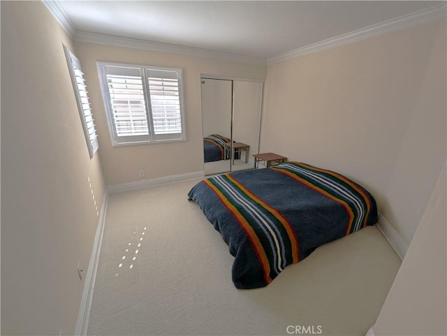 carpeted bedroom with ornamental molding, a closet, and baseboards