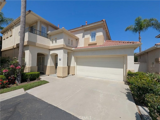 mediterranean / spanish home with a balcony, a tiled roof, concrete driveway, and stucco siding